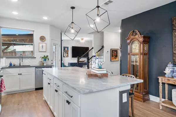 a kitchen with kitchen island granite countertop a stove a oven a dining table and chairs