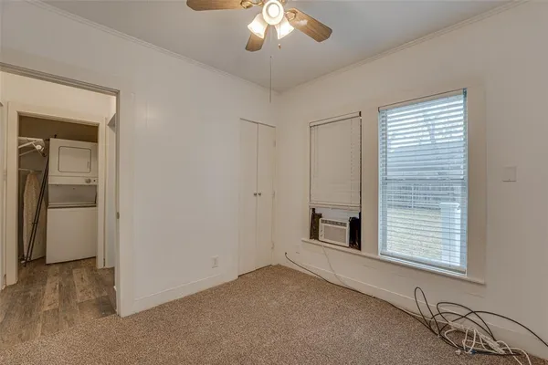 a view of empty room with windows and ceiling fan