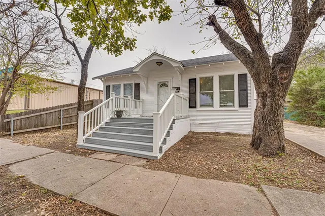 a view of a house with a tree in front of it