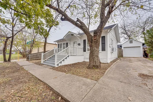a white house that has a tree in front of it