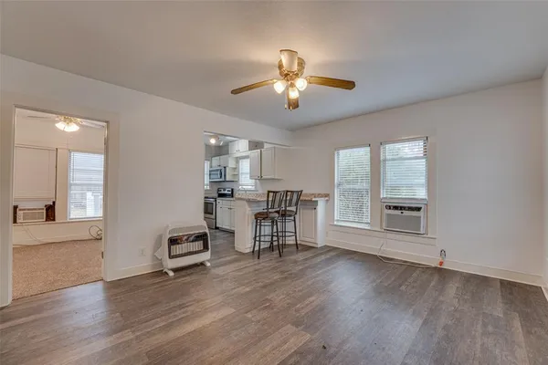 a view of a livingroom with furniture hardwood floor a ceiling fan and windows