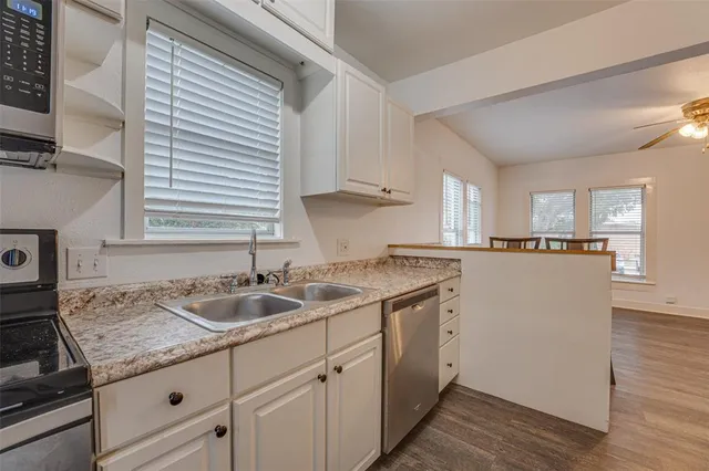 a kitchen with stainless steel appliances granite countertop a sink a stove and cabinets