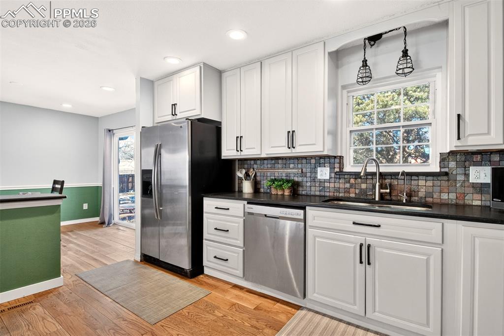 5226 Rocking R Drive Colorado Springs, CO 80915 - Photo 18 of 46 a kitchen with granite countertop white cabinets and stainless steel appliances