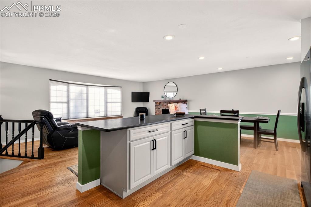 5226 Rocking R Drive Colorado Springs, CO 80915 - Photo 19 of 46 a kitchen with cabinets a sink dishwasher stove and chairs with wooden floor