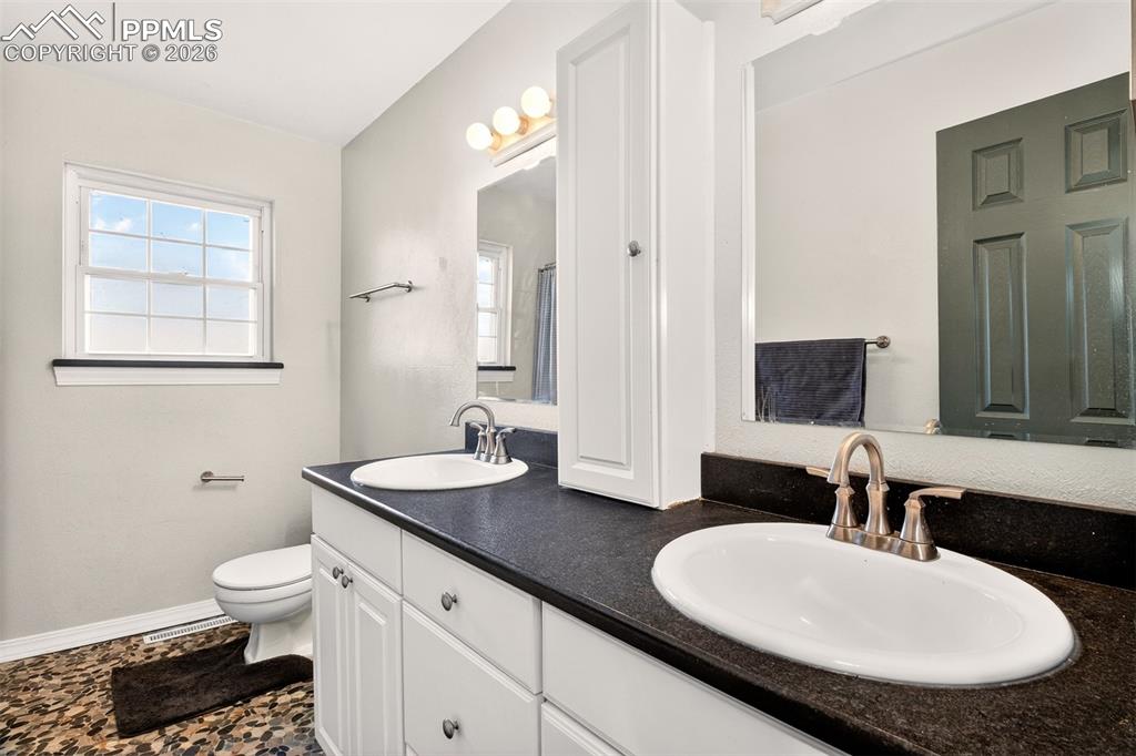 5226 Rocking R Drive Colorado Springs, CO 80915 - Photo 25 of 46 a bathroom with a granite countertop sink and a mirror