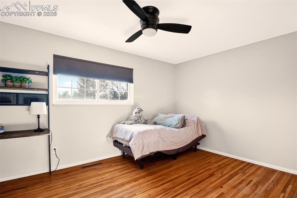 5226 Rocking R Drive Colorado Springs, CO 80915 - Photo 27 of 46 a bedroom with a bed and wooden floor
