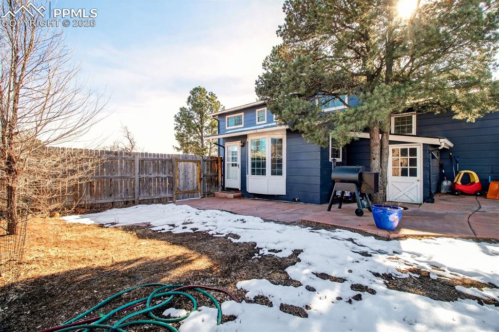 5226 Rocking R Drive Colorado Springs, CO 80915 - Photo 44 of 46 a view of a backyard with wooden fence and a tree