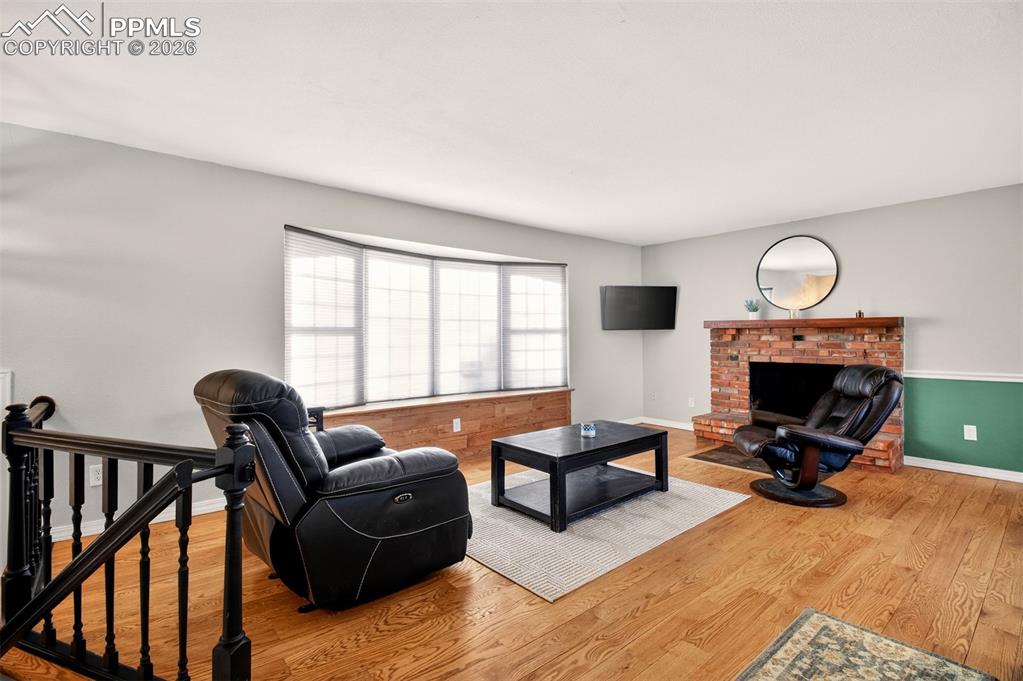 5226 Rocking R Drive Colorado Springs, CO 80915 - Photo 10 of 46 a living room with furniture a fireplace and a large window