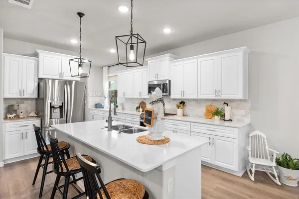 a kitchen with refrigerator cabinets dining table and chairs