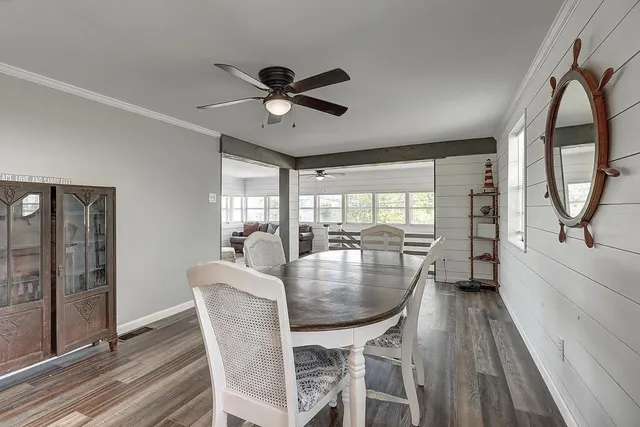 a dining room with furniture a chandelier and wooden floor