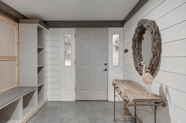 a view of a livingroom with wooden floor and a bathroom