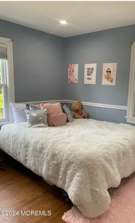 a bedroom with a bed and painting on the wall