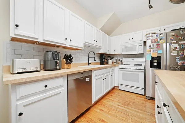 a kitchen with white cabinets and white appliances