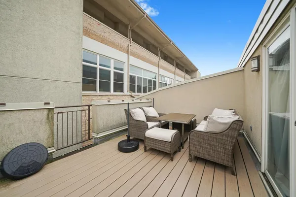 a view of a balcony with chair and wooden floor