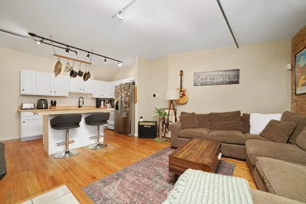 a living room with furniture and a dining table with kitchen view