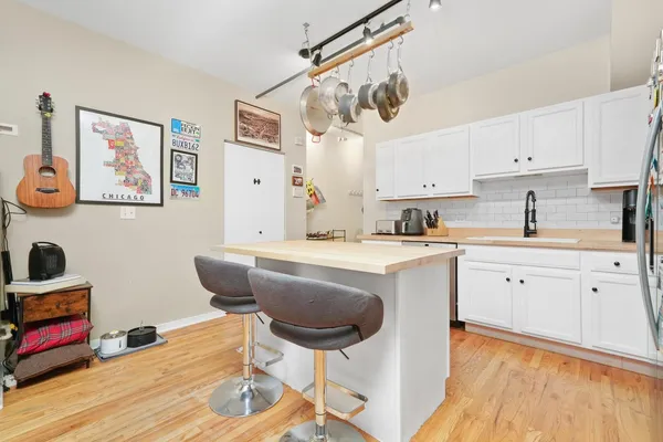 a kitchen with stainless steel appliances a stove a sink cabinets and wooden floor