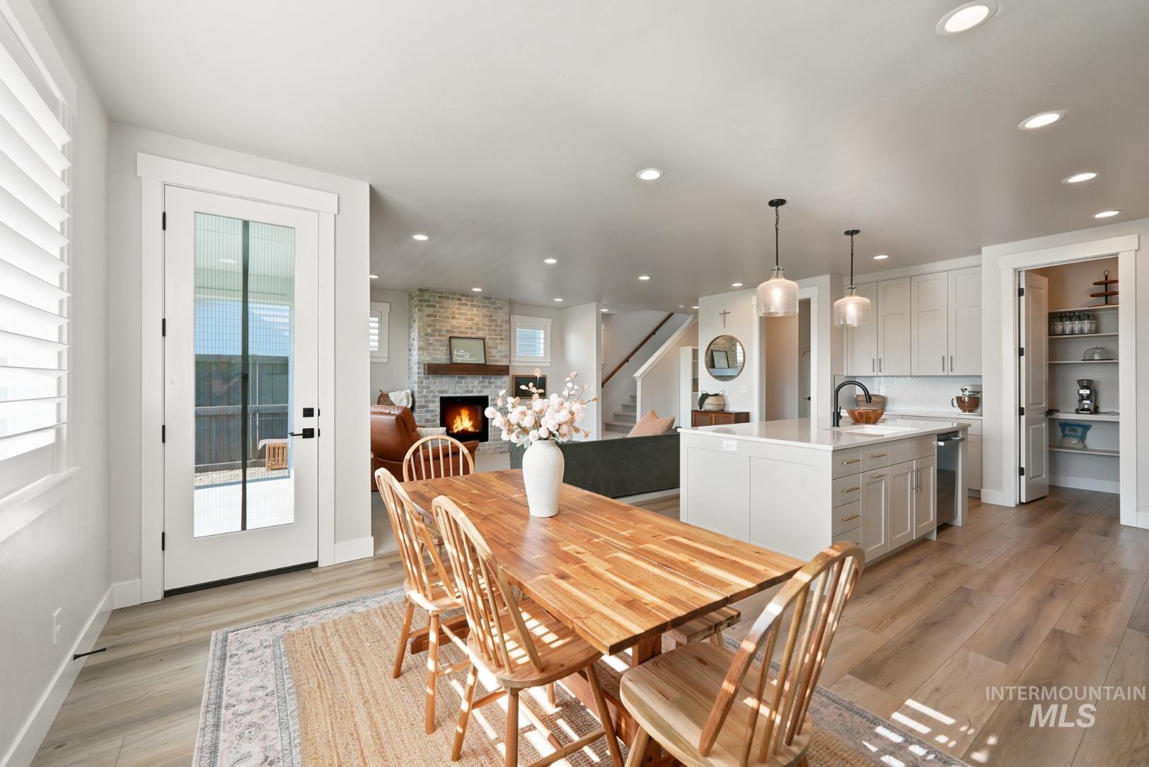 6933 South Zenith Avenue Meridian, ID 83642 - Photo 11 of 34 Open-concept interior featuring light wood-finish flooring, recessed lighting, and a white kitchen island with pendant fixtures