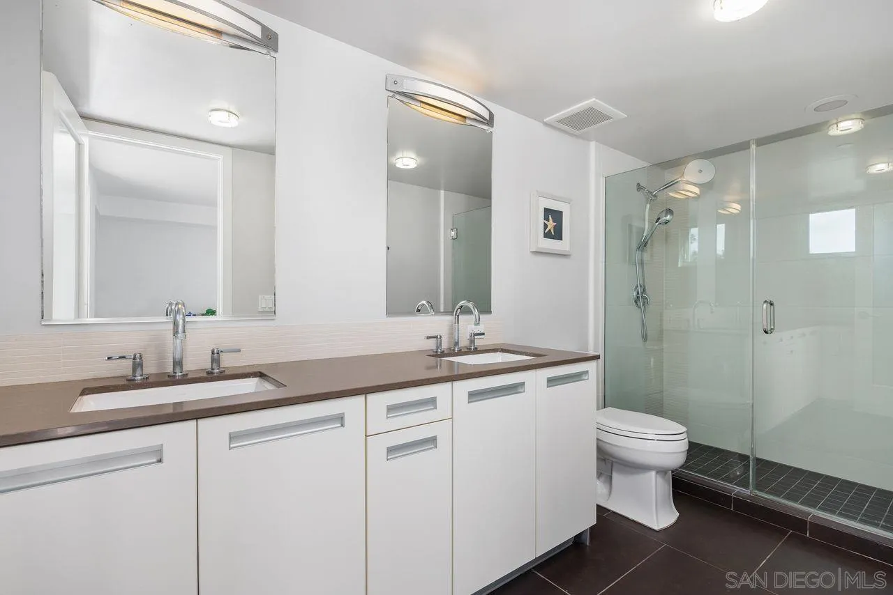 90 North Coast Highway 101 Encinitas, CA 92024 - Photo 25 of 39 a bathroom with a double vanity sink toilet and a mirror