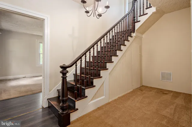 an empty room with a ceiling fan and carpet
