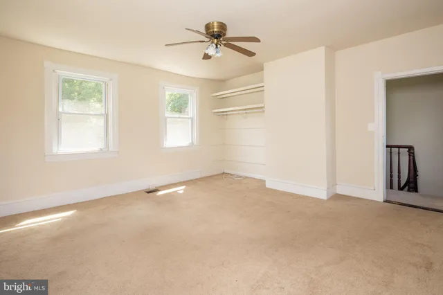 a view of a hallway with wooden floor and closet