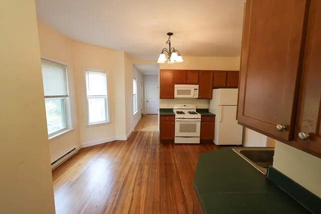 a kitchen with wooden floors and appliances
