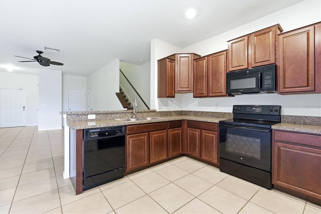 12909 Dream Catcher Way Riverview, FL 33579 - Photo 13 of 32 a kitchen with stainless steel appliances granite countertop a stove a sink and a microwave