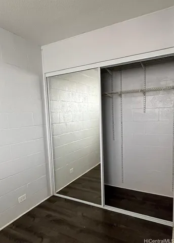 an empty room with wooden floor and closet
