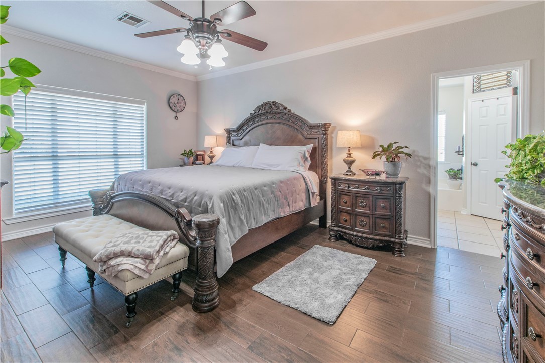 876 South St Joseph Road Burlington, TX 76519 - Photo 11 of 35 a spacious bedroom with a bed a couch and potted plant on the dresser