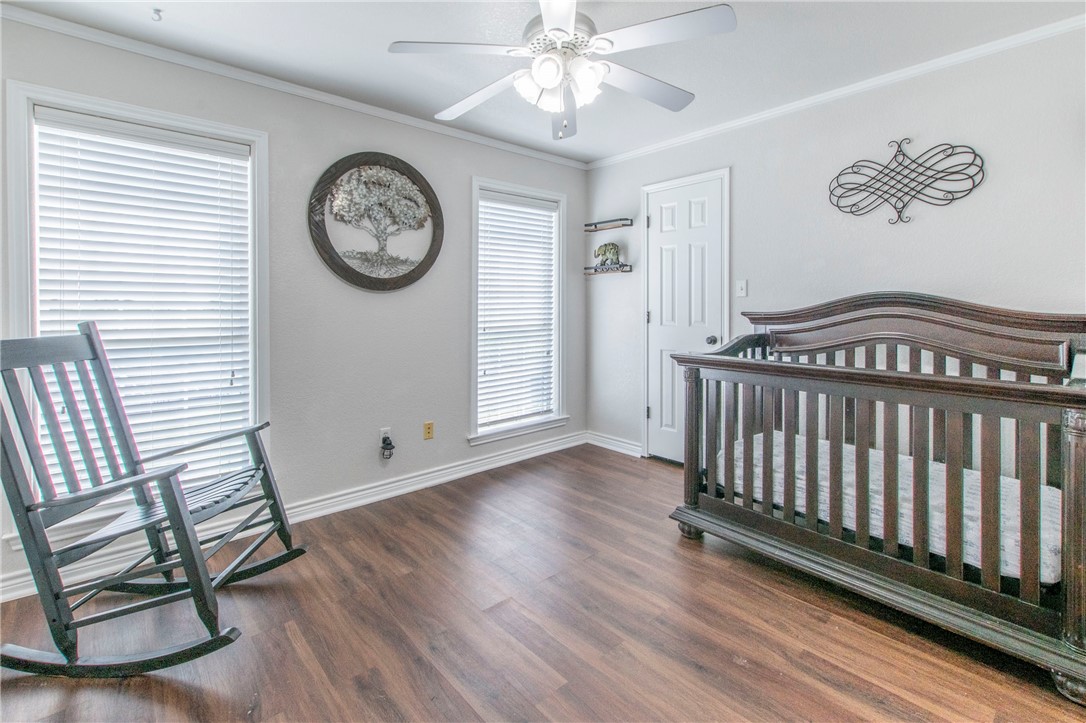 876 South St Joseph Road Burlington, TX 76519 - Photo 20 of 35 a view of a room with wooden floor and a ceiling fan