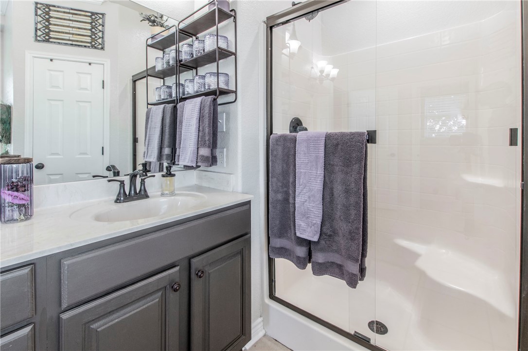 876 South St Joseph Road Burlington, TX 76519 - Photo 24 of 35 a bathroom with a sink a mirror and a shower