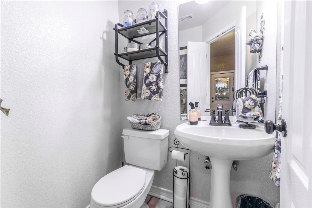 876 South St Joseph Road Burlington, TX 76519 - Photo 27 of 35 a bathroom with a toilet sink and mirror