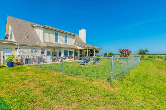 a backyard of a house with table and chairs