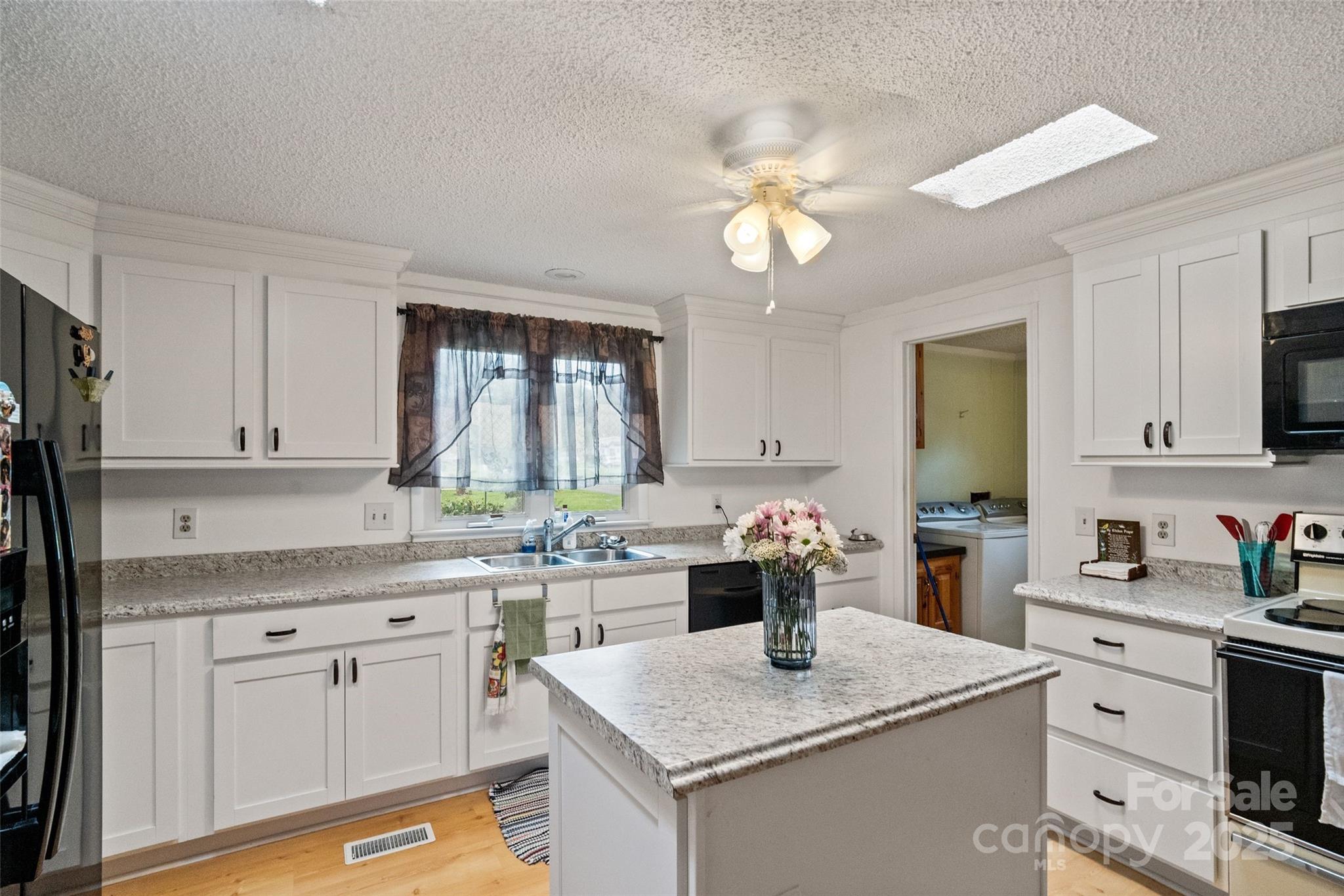 5909 Lake Valley Road Clover, SC 29710 - Photo 13 of 44 a kitchen with a sink dishwasher and white cabinets with wooden floor