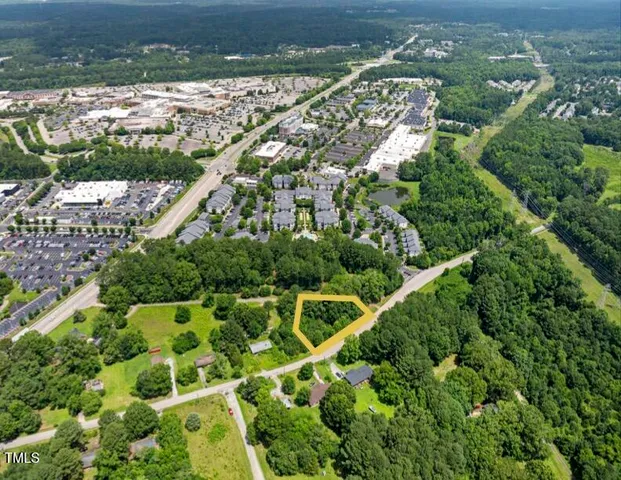 an aerial view of residential houses with outdoor space and trees