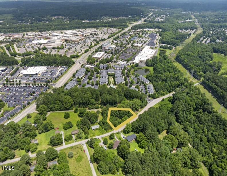 an aerial view of residential houses with outdoor space and trees