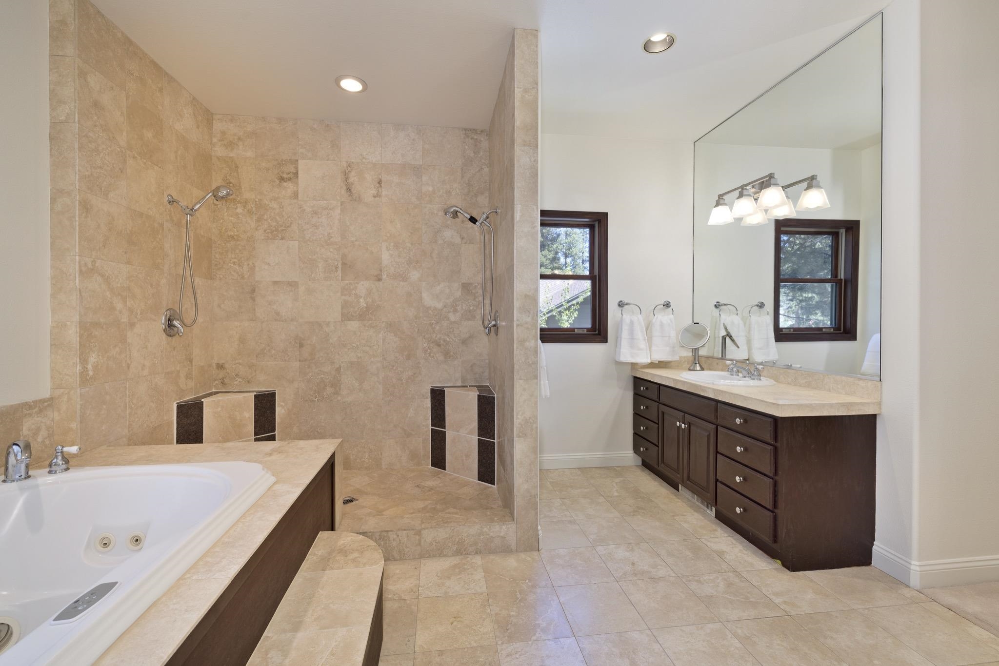 378 Ridge Way Mammoth Lakes, CA 93546 - Photo 27 of 43 Spacious bathroom featuring a jetted soaking tub, walk-in shower with dual shower heads and built-in benches, and a double vanity with ample storage