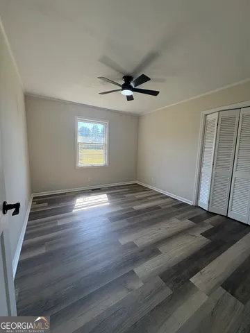 a view of a livingroom with wooden floor and a ceiling fan