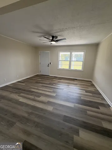 en empty room with windows and ceiling fan