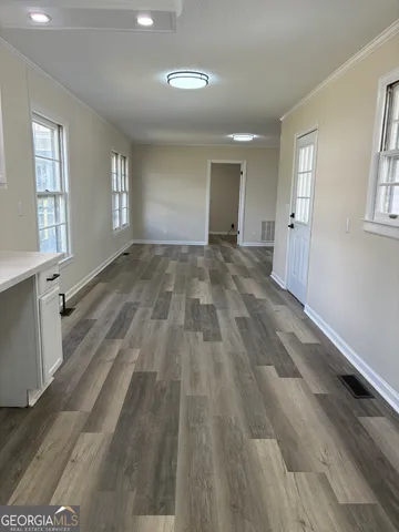 an empty room with wooden floor and windows