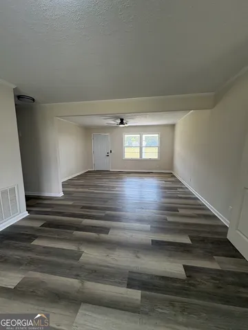 a view of an empty room and wooden floor