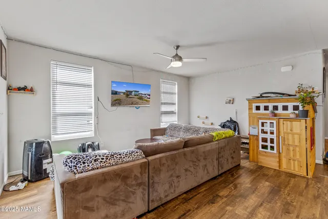 a living room with furniture a flat screen tv and a window