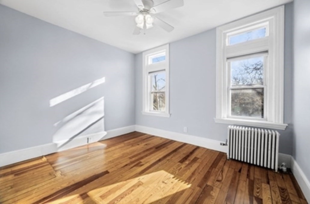 1834 Beacon Street, Unit 5 Brookline, MA 02445 - Photo 3 of 6 a view of an empty room with wooden floor and a window