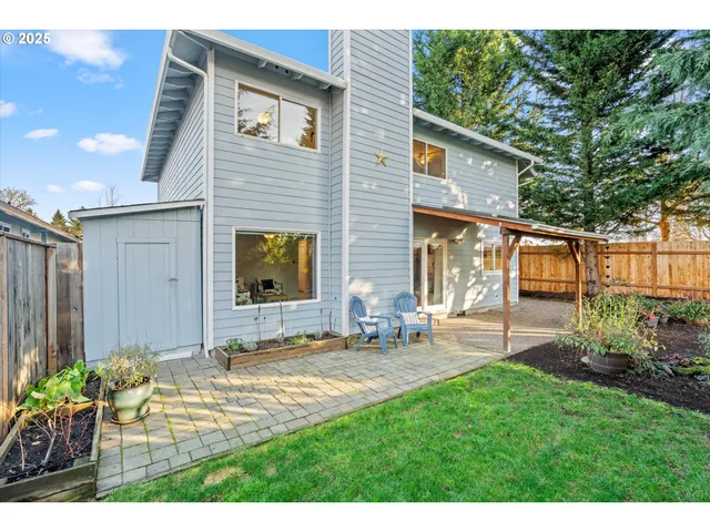 a view of a chair and table in backyard of the house