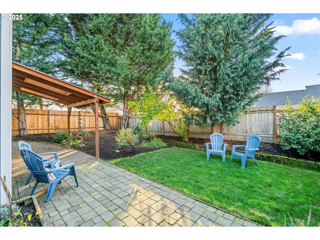 a backyard of a house with table and chairs