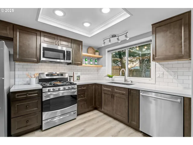 a kitchen with stainless steel appliances granite countertop a stove and cabinets