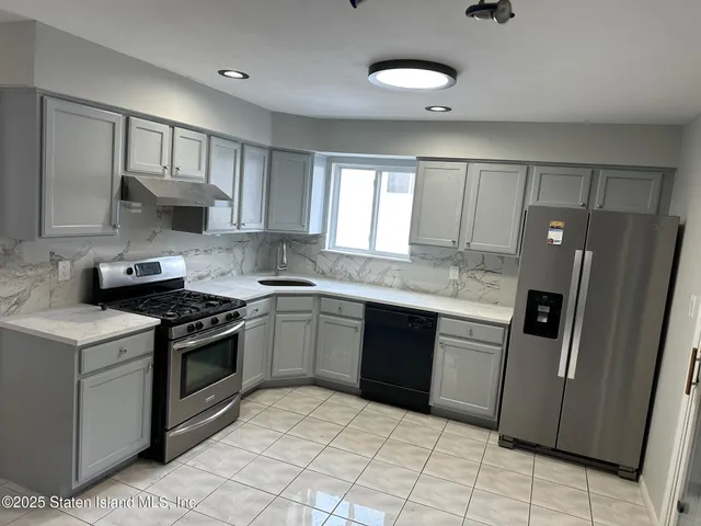 a kitchen with stainless steel appliances granite countertop a stove a sink dishwasher and a refrigerator
