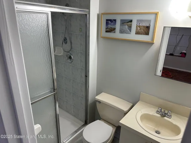 a white toilet sitting next to a bathroom sink and a shower