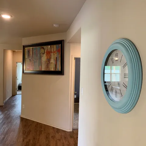 an empty room with wooden floor mirror and windows