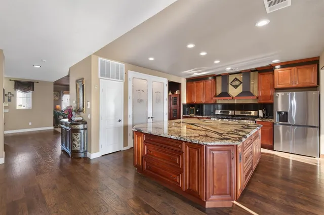 a kitchen with stainless steel appliances granite countertop a stove and a refrigerator