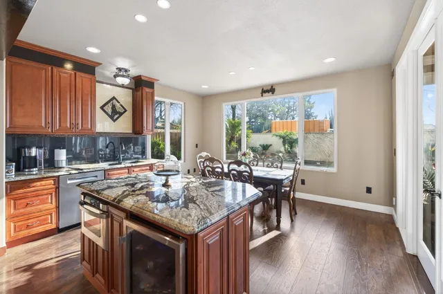 a view of a dining area with furniture a kitchen and chandelier